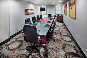 A conference room with a long table, black chairs, and a carpeted floor. - Holiday Inn Atlanta-Northlake by IHG (Atlanta)