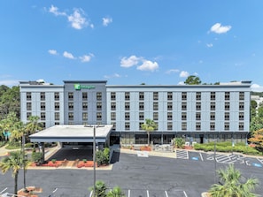 A Holiday Inn hotel with a flat roof, multiple floors, and a parking lot with marked spaces. - Holiday Inn Atlanta-Northlake by IHG (Atlanta)