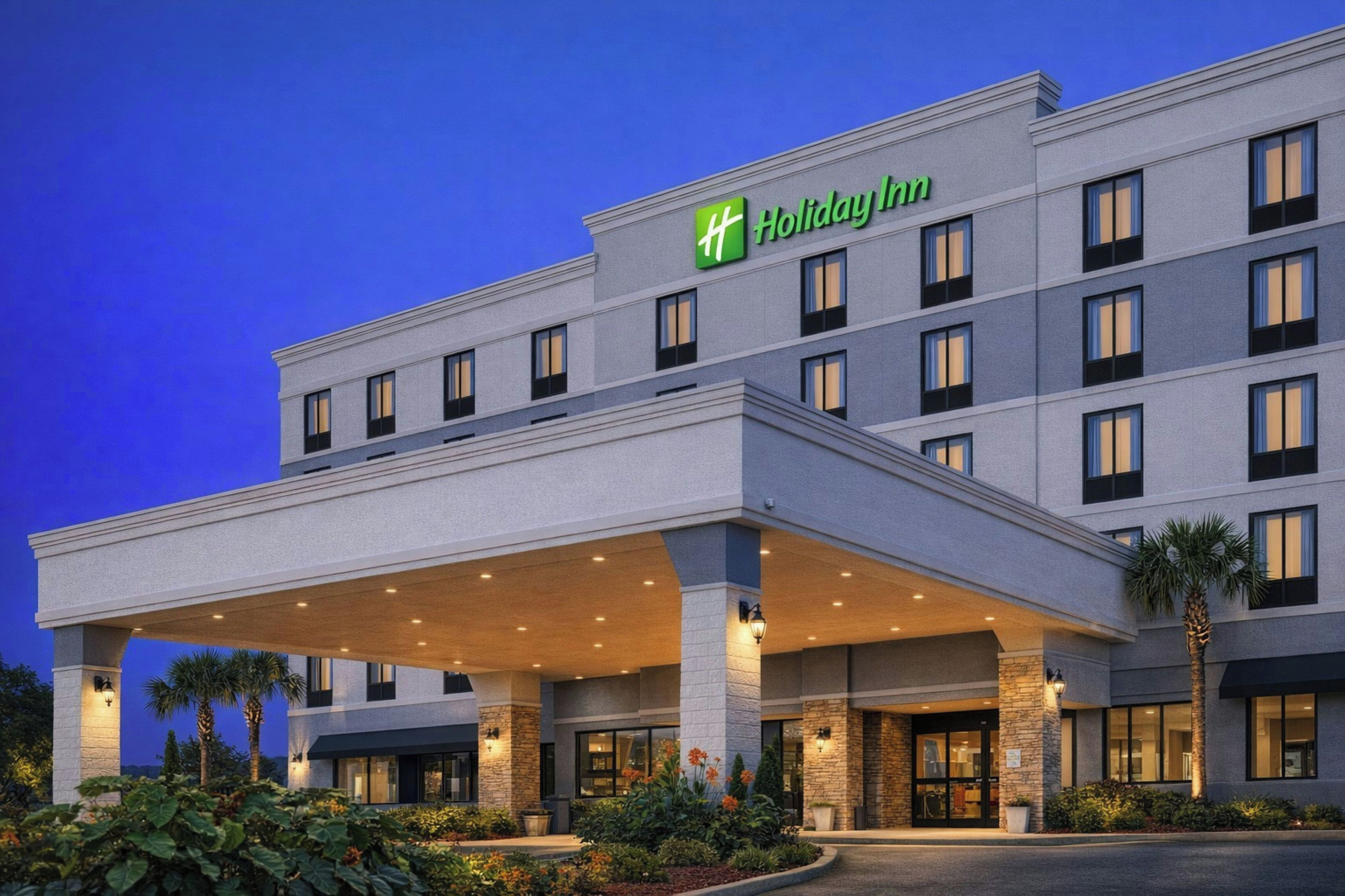A Holiday Inn hotel with a covered entrance, multiple floors, and a landscaped front garden.