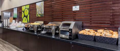 A buffet counter with various food items and a coffee station.