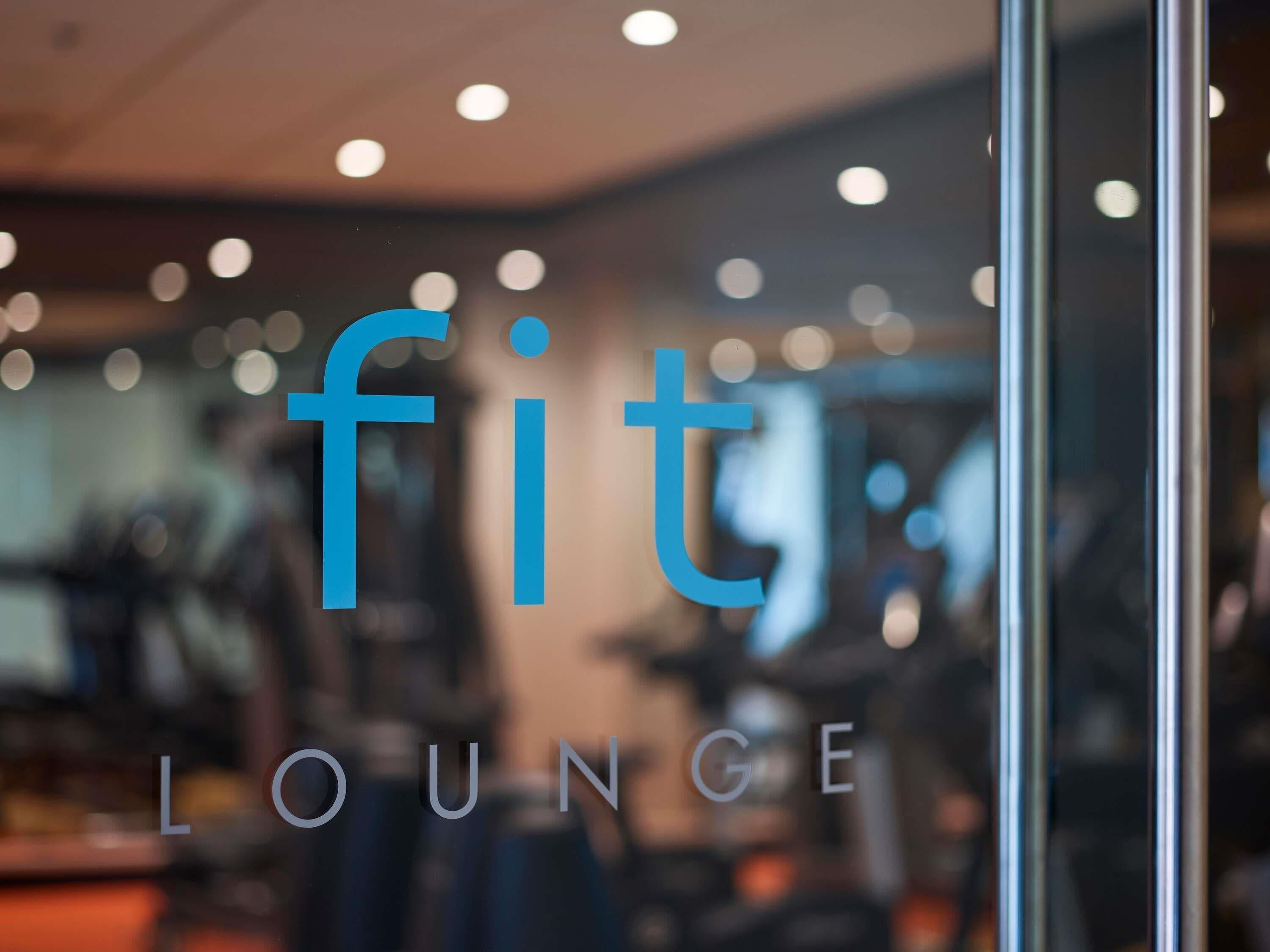 A blurred interior of a fitness center with the text 'fit lounge' visible.
