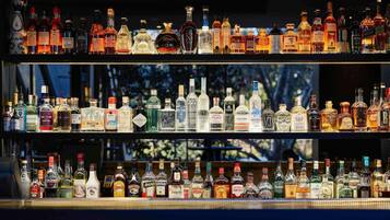 Un bar con varias estanterías llenas de diferentes botellas de licores.