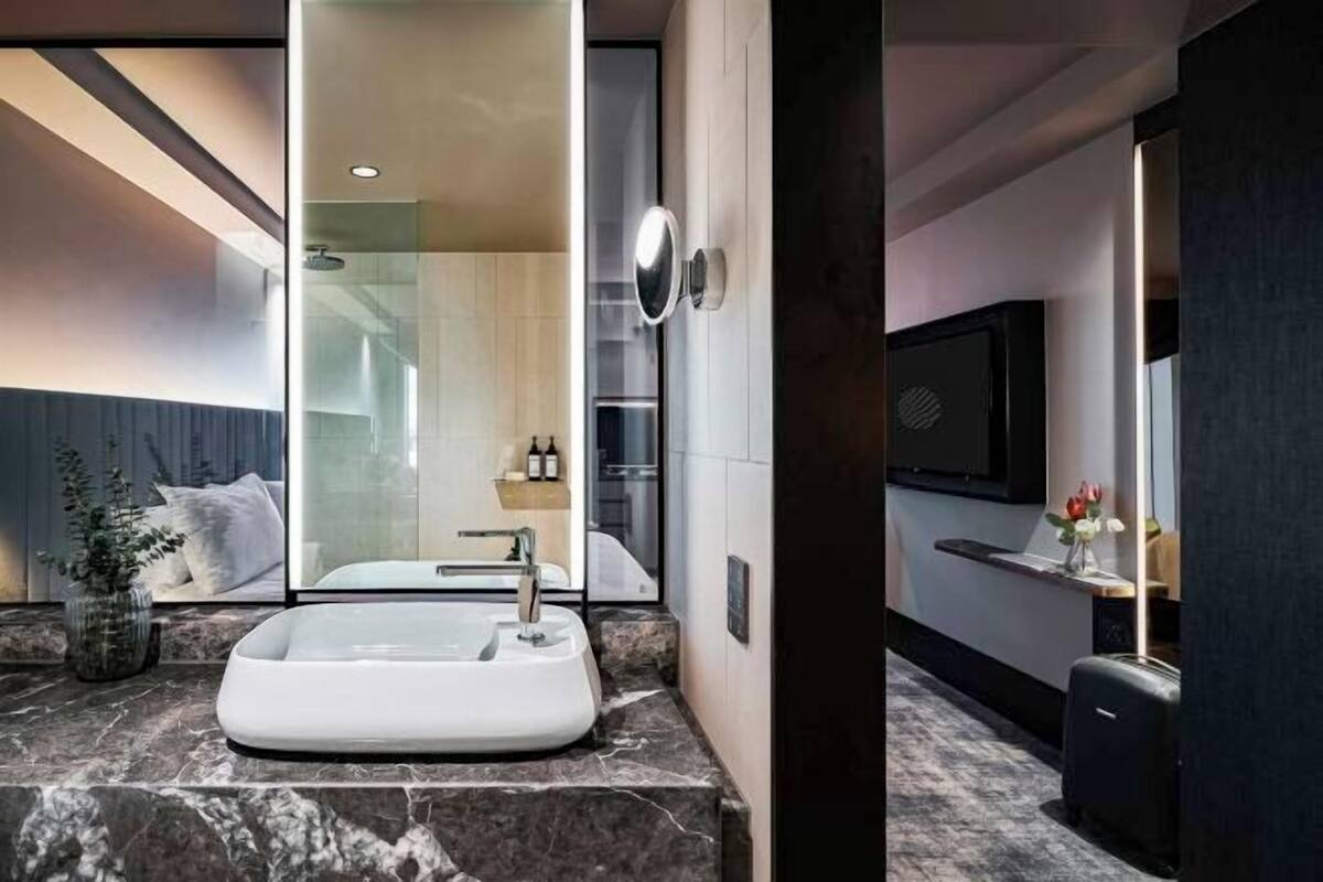 Badkamer | Een douche, designer toiletartikelen, een haardroger, badjassen