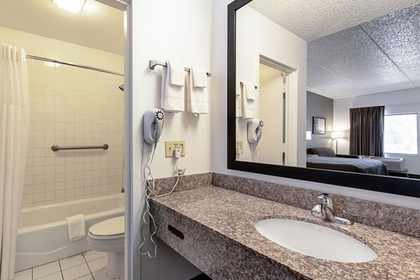 A bathroom with a shower, toilet, and sink.