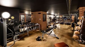 A gym with various exercise equipment, including treadmills, dumbbells, and weight plates. - pentahotel Reading (Reading)