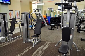 A gym with various exercise equipment, including weight machines and free weights. - DoubleTree by Hilton Hotel Binghamton (Binghamton)