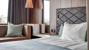 A modern hotel room with a bed, a seating area, and a large window. - Quality Airport Hotel Stavanger (Sola)