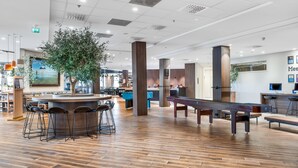 A spacious indoor area with a pool table, bar stools, and a large plant. - Quality Airport Hotel Stavanger (Sola)