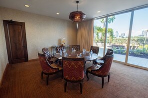 A conference room with a round table, leather chairs, and a city view through large windows.