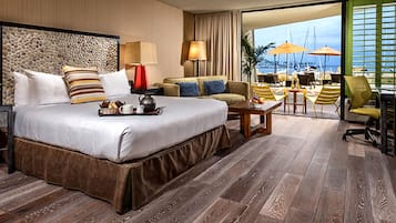 Enjoy a comfortable stay in this spacious room with a large bed, breakfast tray, and seating area offering a view of the sea.