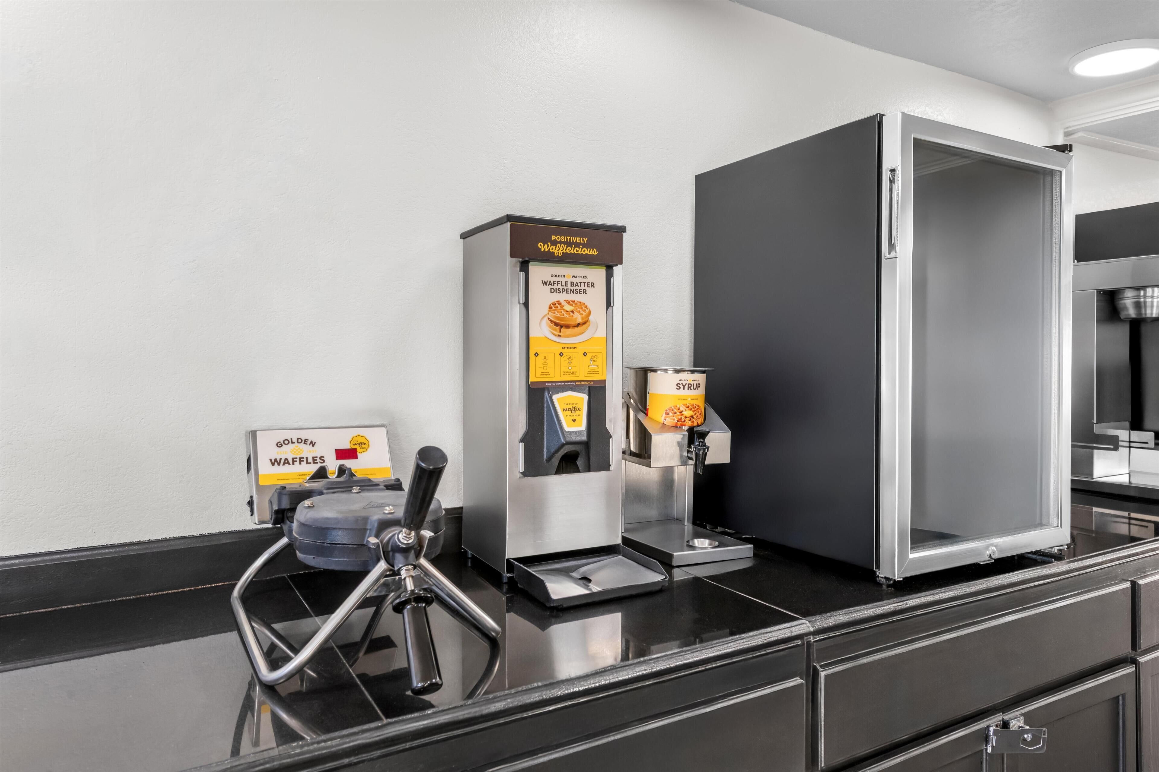 A waffle dispenser and syrup dispenser in a commercial setting.