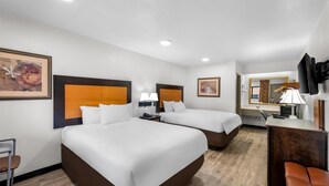 A hotel room with two beds, a desk, a chair, and a TV. - Americas Best Value Inn Kansas City E Independence (Independence)