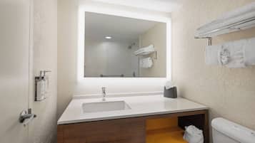 Un baño moderno con un espejo grande, un lavabo, un inodoro y un perchero para toallas.