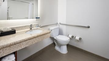 A modern bathroom with a sink, toilet, and handrails.