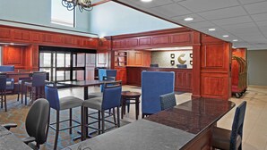 A hotel lobby with a bar area, seating arrangements, and a view of the outdoors. - Comfort Suites Outlet Center (Asheville)