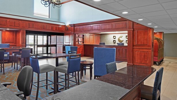 A hotel lobby with a bar area, seating arrangements, and a view of the outdoors. - Comfort Suites Outlet Center (Asheville)