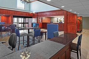 A hotel lobby with a bar area, seating arrangements, and a view of the outdoors. - Comfort Suites Outlet Center (Asheville)