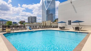 A swimming pool with lounge chairs and umbrellas, surrounded by modern buildings. - Embassy Suites by Hilton Atlanta Buckhead (Atlanta)