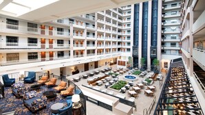 A multi-level hotel atrium with a central courtyard, balconies, and a variety of seating areas. - Embassy Suites by Hilton Atlanta Buckhead (Atlanta)