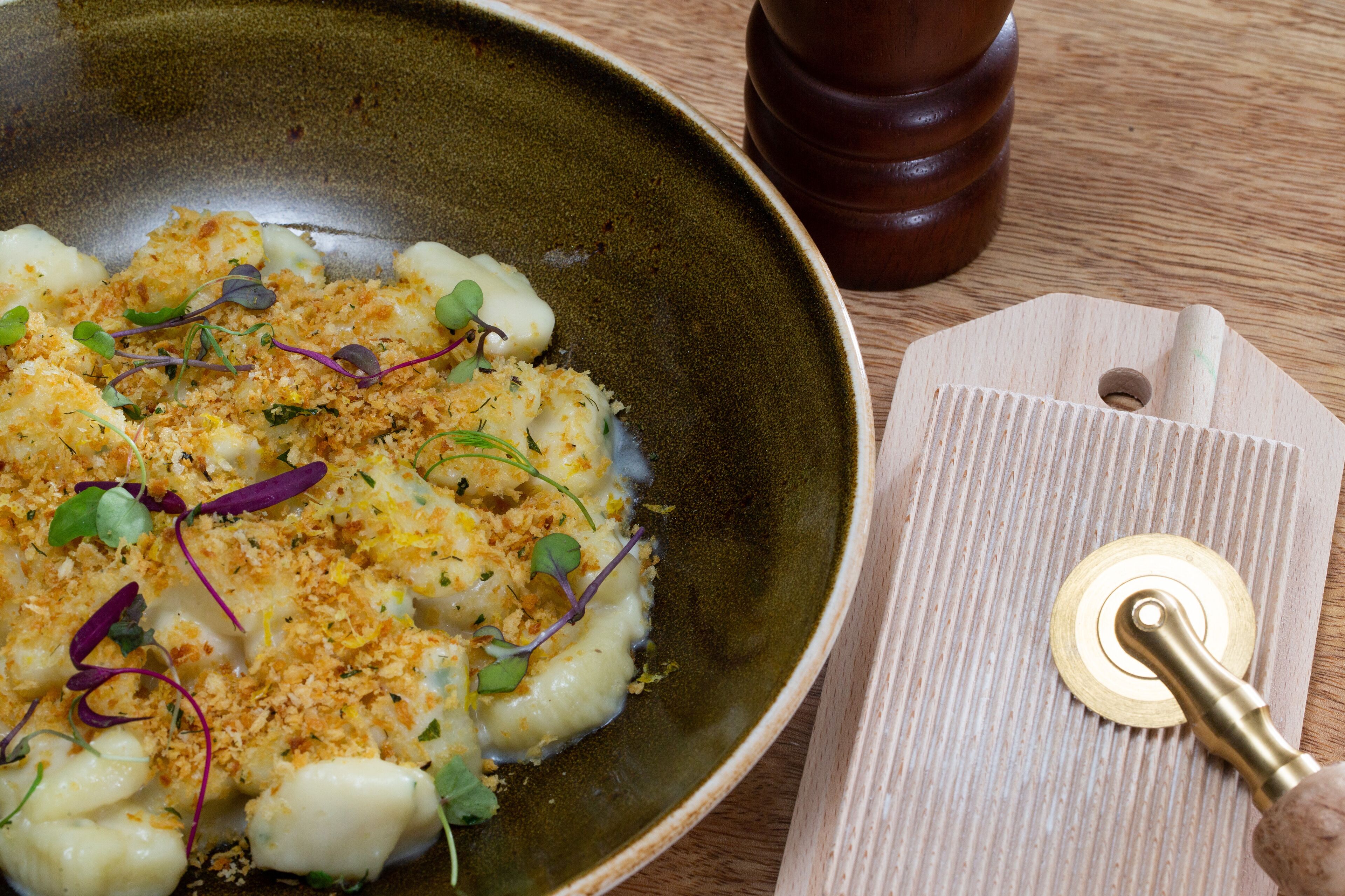 A plate of food with a wooden cutting board and a pepper mill.