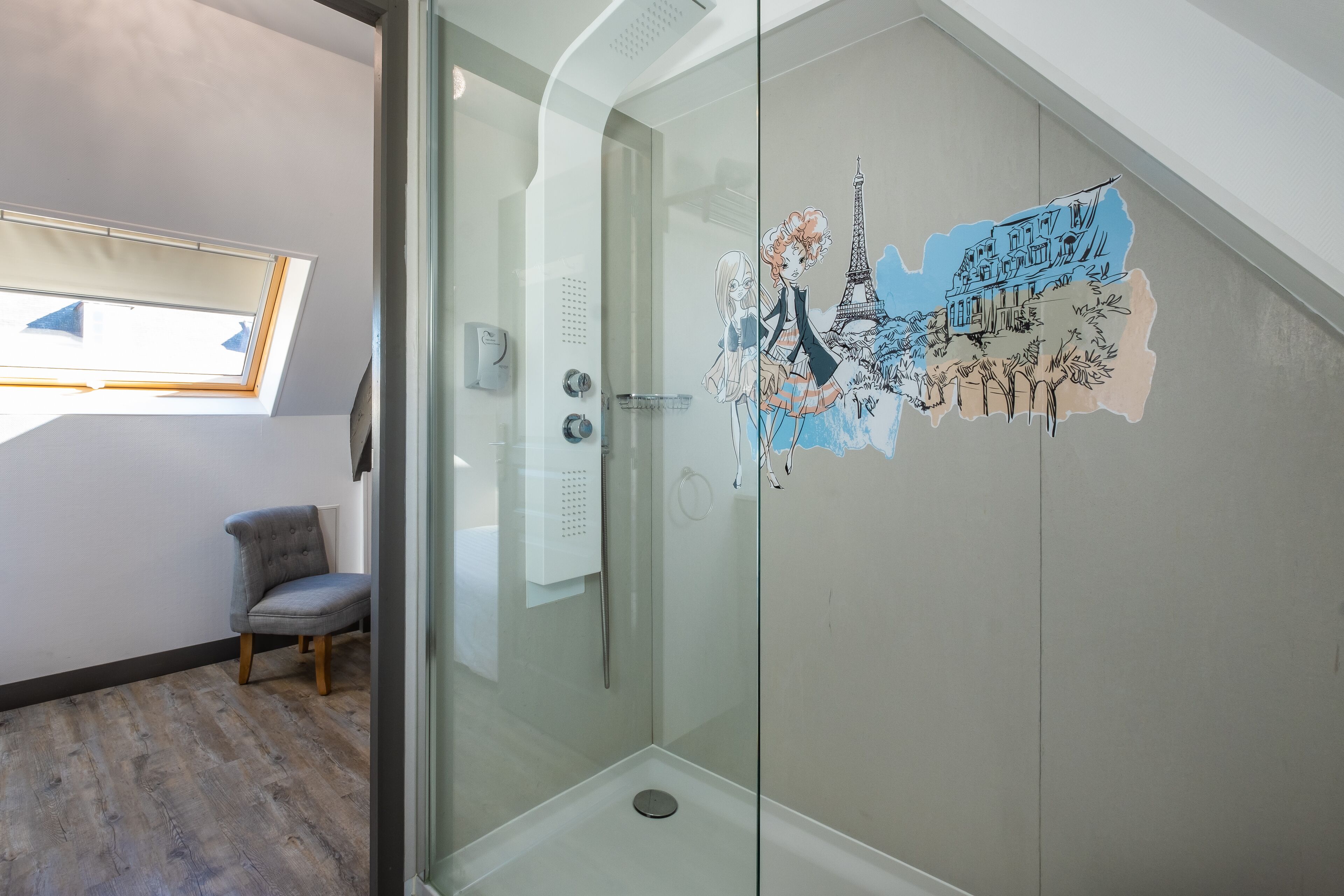 A modern bathroom with a glass shower enclosure, a skylight, and a decorative wall sticker.