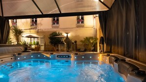 A hot tub area with multiple seating sections and a covered patio.