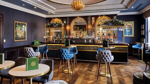 A bar area with a polished wooden floor, bar stools, and a well-stocked bar counter. - The Clermont London, Charing Cross (London)