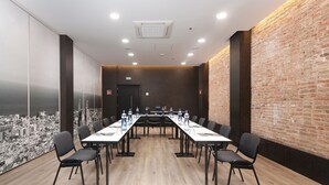 A conference room with a long table, chairs, and a cityscape mural on the wall. - Hotel HCC Regente (Barcelona)