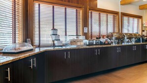 Mostrador de buffet con encimera de mármol, paneles de madera y una variedad de alimentos.