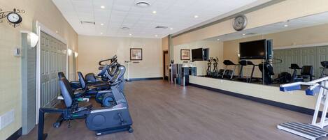 A spacious gym with multiple treadmills, stationary bikes, and exercise equipment.