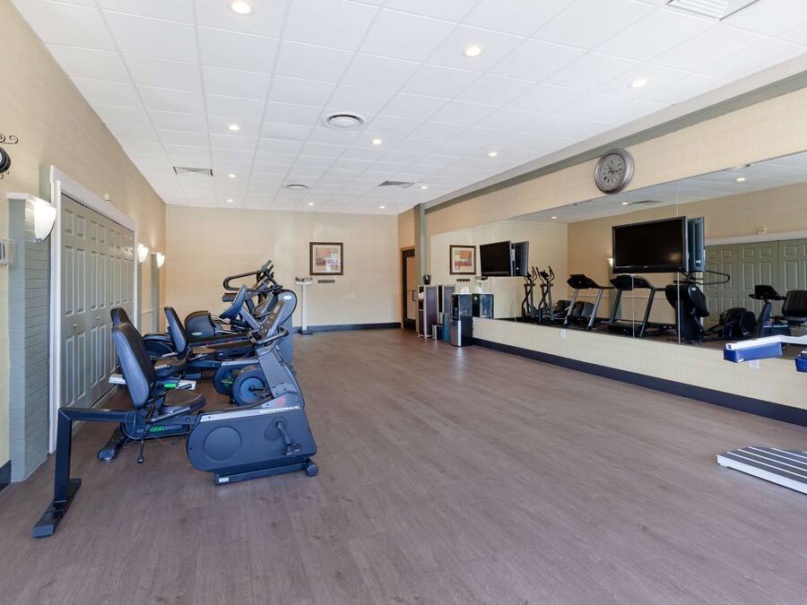 Un'ampia palestra con tapis roulant, cyclette e attrezzature per l'allenamento.