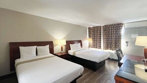 Ein Hotelzimmer mit zwei Betten, einem Schreibtisch und einem Sessel.