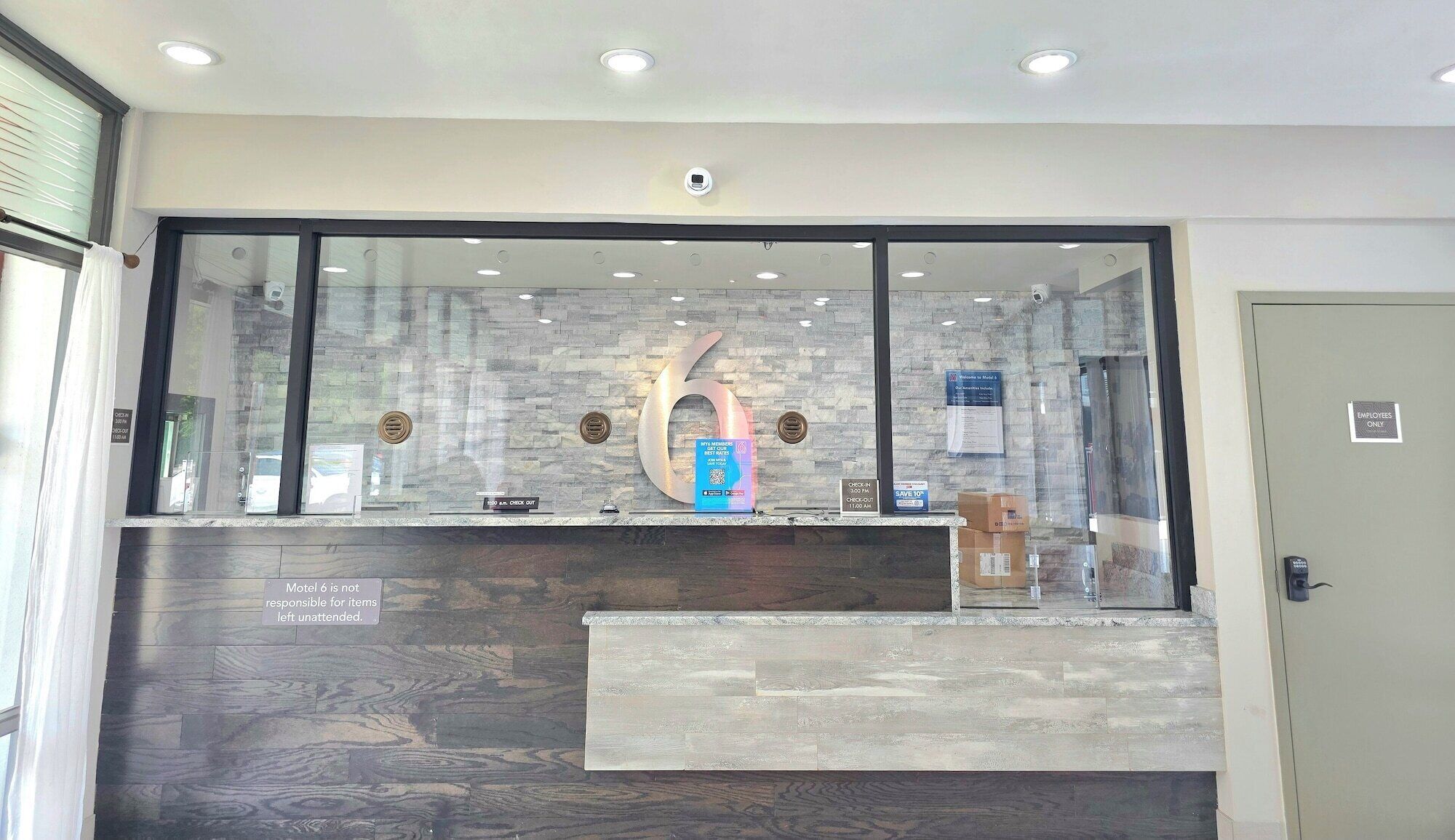 A reception desk with a large number '6' sign, a check-in counter, and a sign indicating 'Employees Only' access.