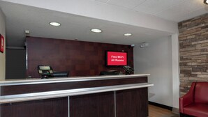A reception desk with a digital screen displaying 'Free Wi-Fi All Rooms.' - Red Roof Inn Washington DC - Lanham (Lanham)
