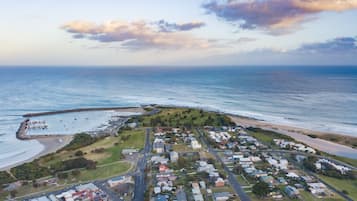 An aerial view of a coastal town with a marina, residential areas, and a beach.