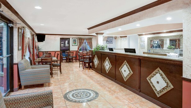 A lobby with a reception desk, seating area, and a patterned floor.
