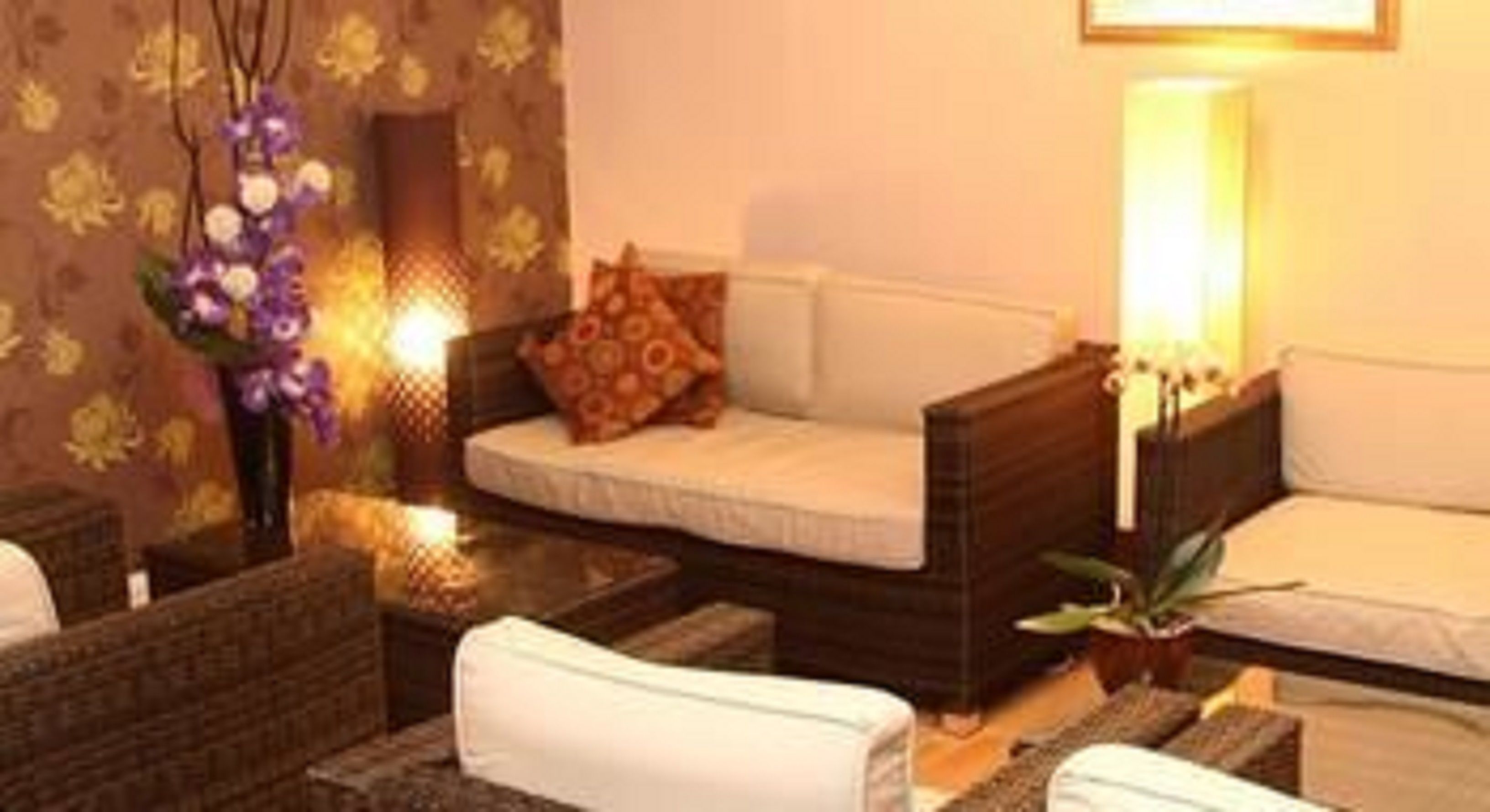 A cozy room with a sofa, a small table, and a decorative vase with flowers.