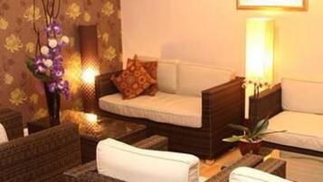 A cozy room with a sofa, a small table, and a decorative vase with flowers.