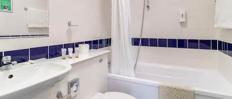 Un baño con lavamanos, inodoro y bañera.