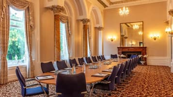 A conference room with a long table, chairs, and a fireplace.