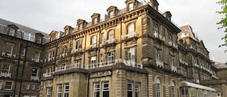 A historic building with multiple floors, large windows, and balconies.