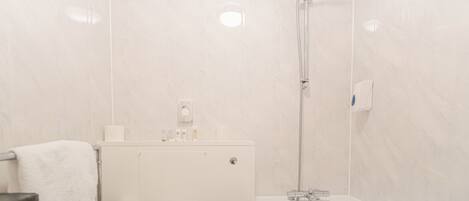 A bathroom with a toilet, a towel rack, a shower, and a bathtub.