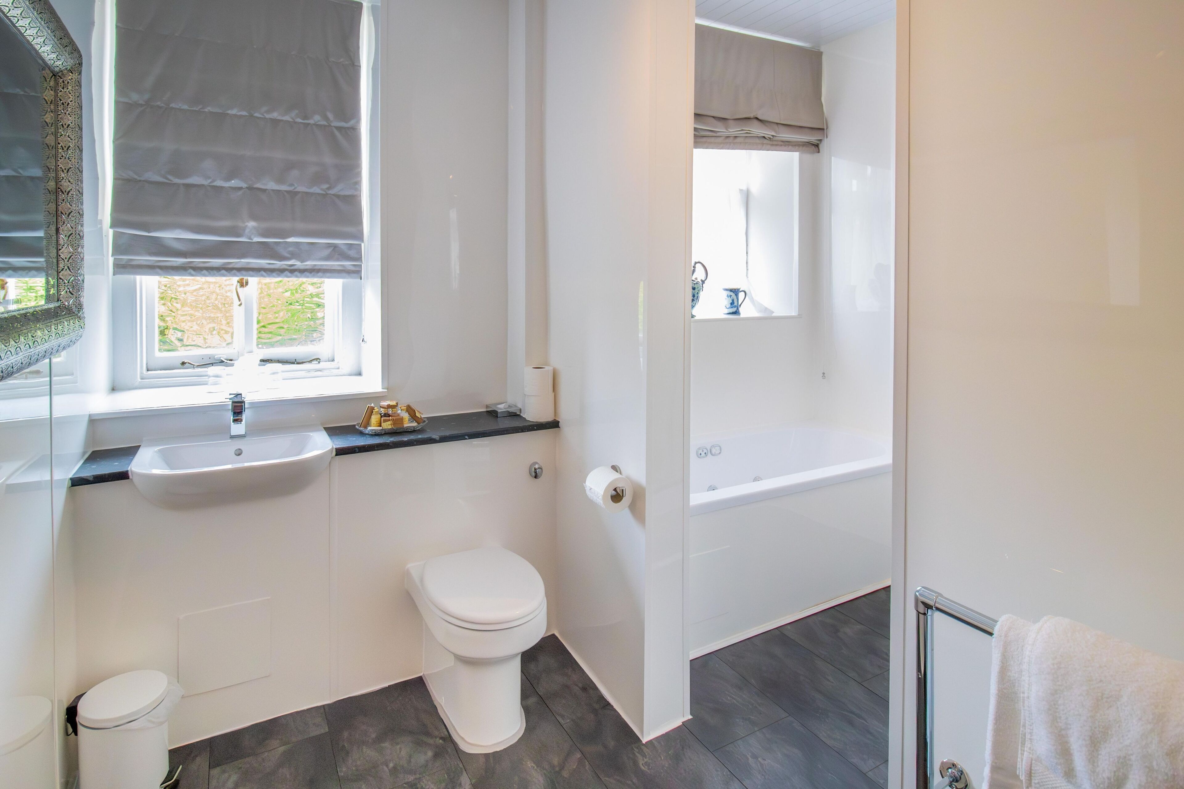A modern bathroom with a toilet, sink, and bathtub.