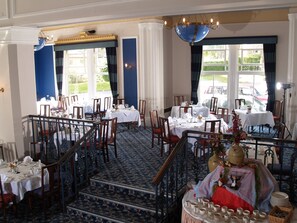 Enjoy meals in style with elegant dining tables, fine silverware, and a beautiful chandelier.