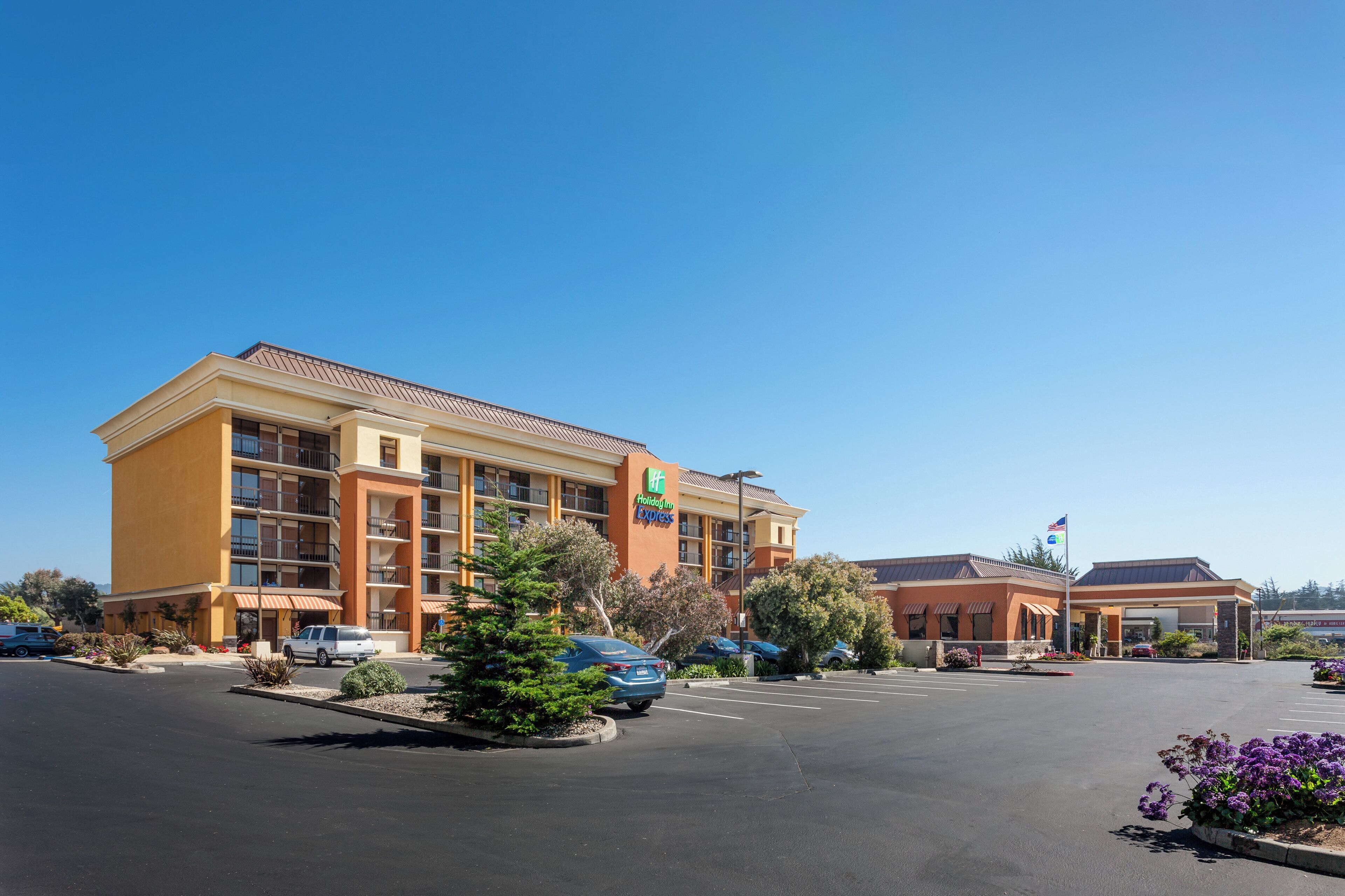 A Holiday Inn Express hotel with a parking lot and a clear blue sky.