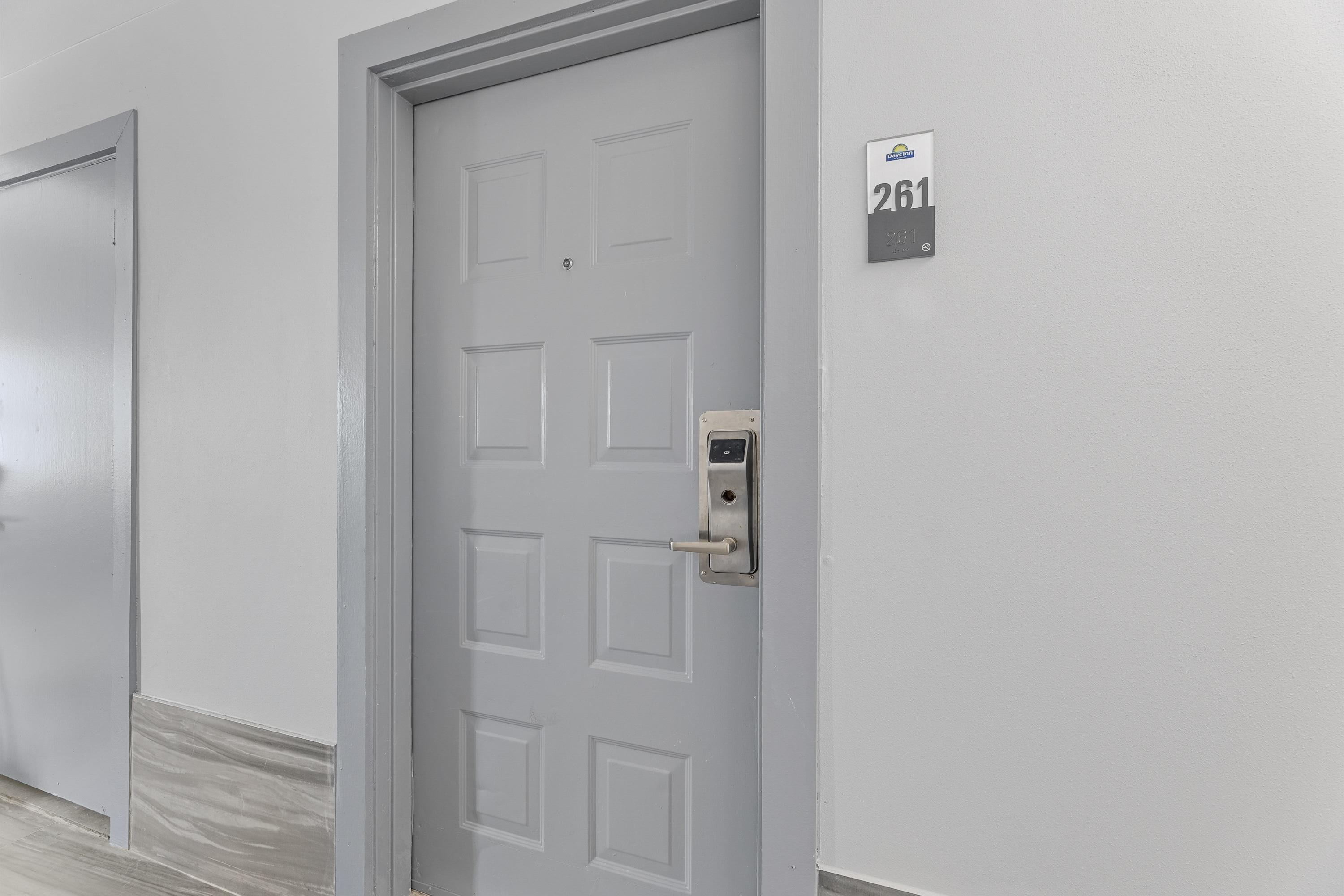 A door with a digital lock and a room number sign.