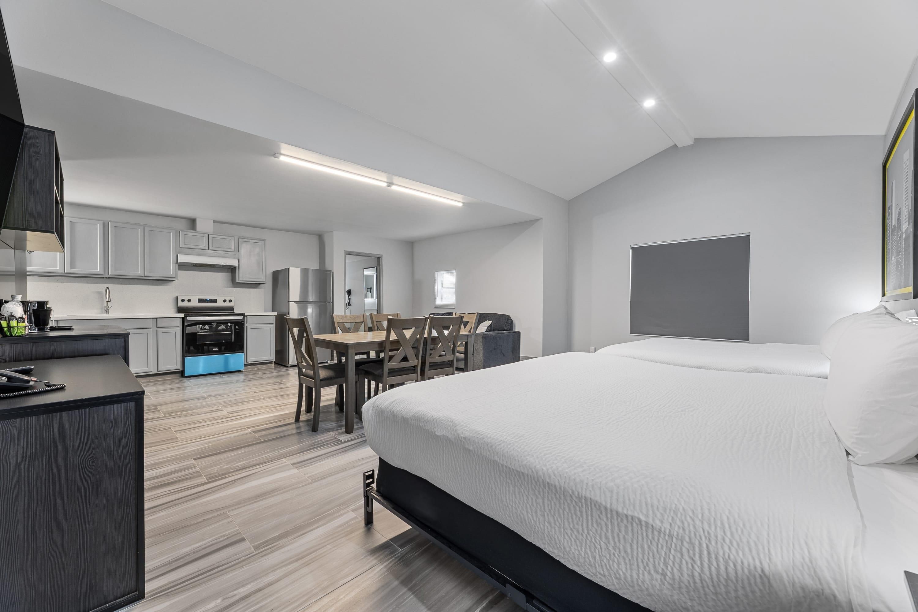 Une chambre d’hôtel moderne dotée d’un grand lit, d’un coin repas et d’une kitchenette.