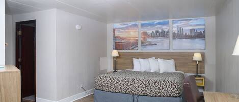 Hotelkamer met een bed, twee bedlampen, een stadsgezicht op de muur en een houten vloer.