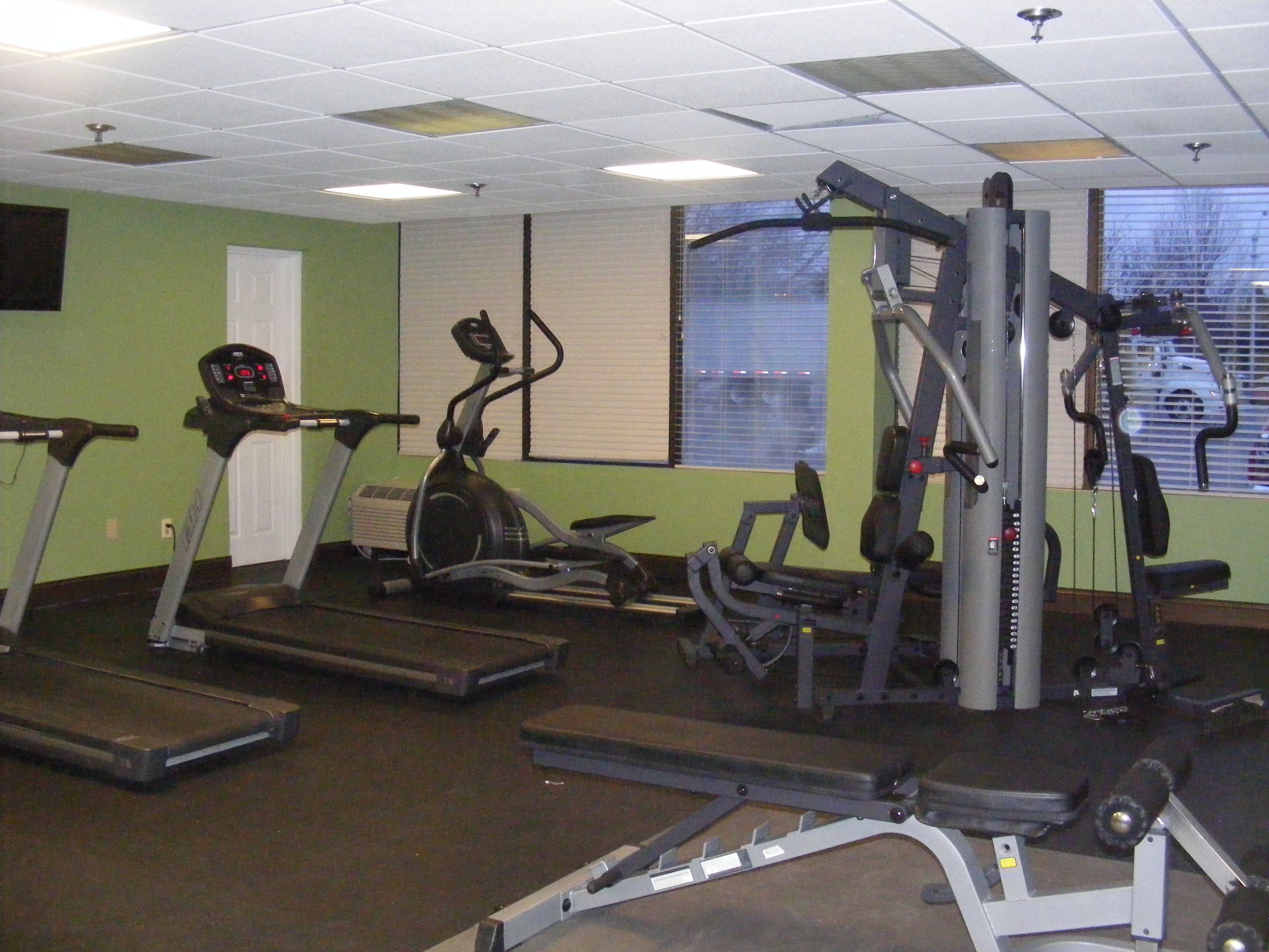 A gym with treadmills, an elliptical, and weight machines.