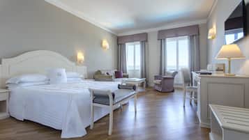 Une chambre d’hôtel avec un grand lit, un bureau, une chaise et un téléviseur.